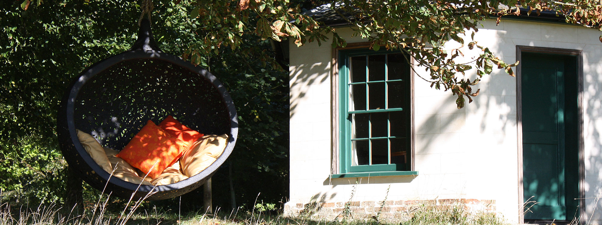 Image of Bios Mini swing seat beneath horse chestnut tree.