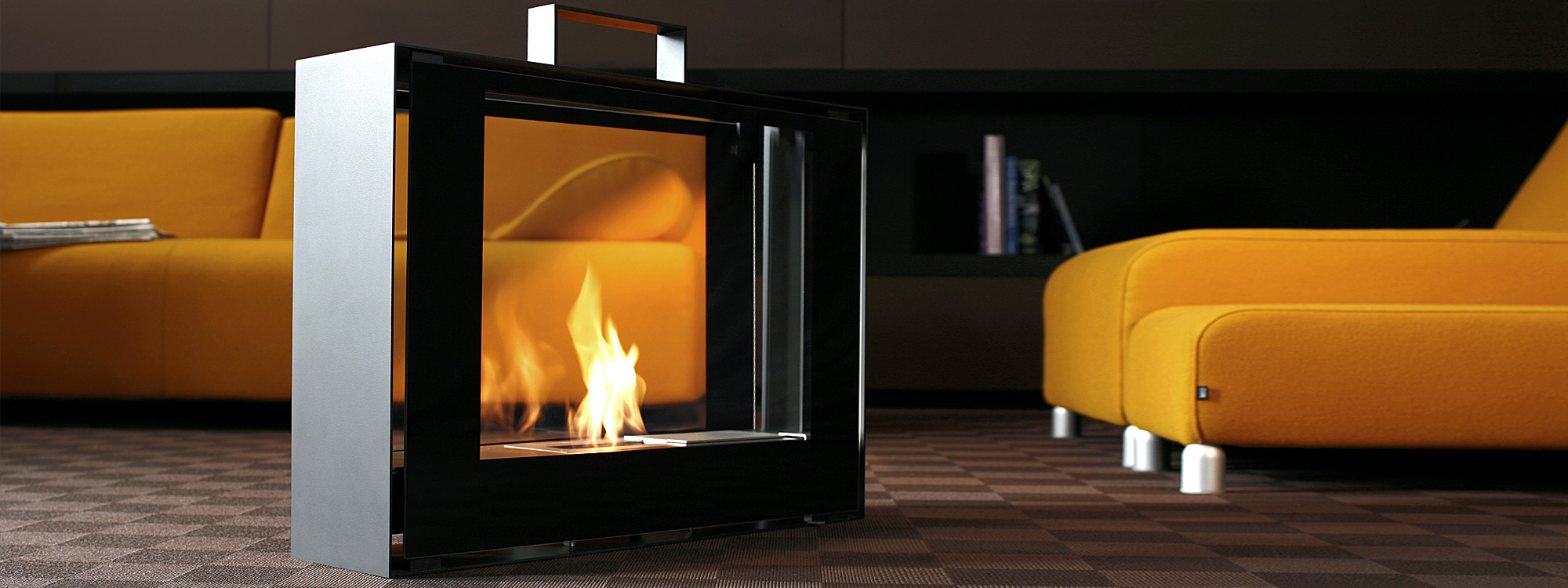 Image of flickering flames within Travelmate modern ethanol fire by Conmoto, with yellow sofa and lounge chair either side