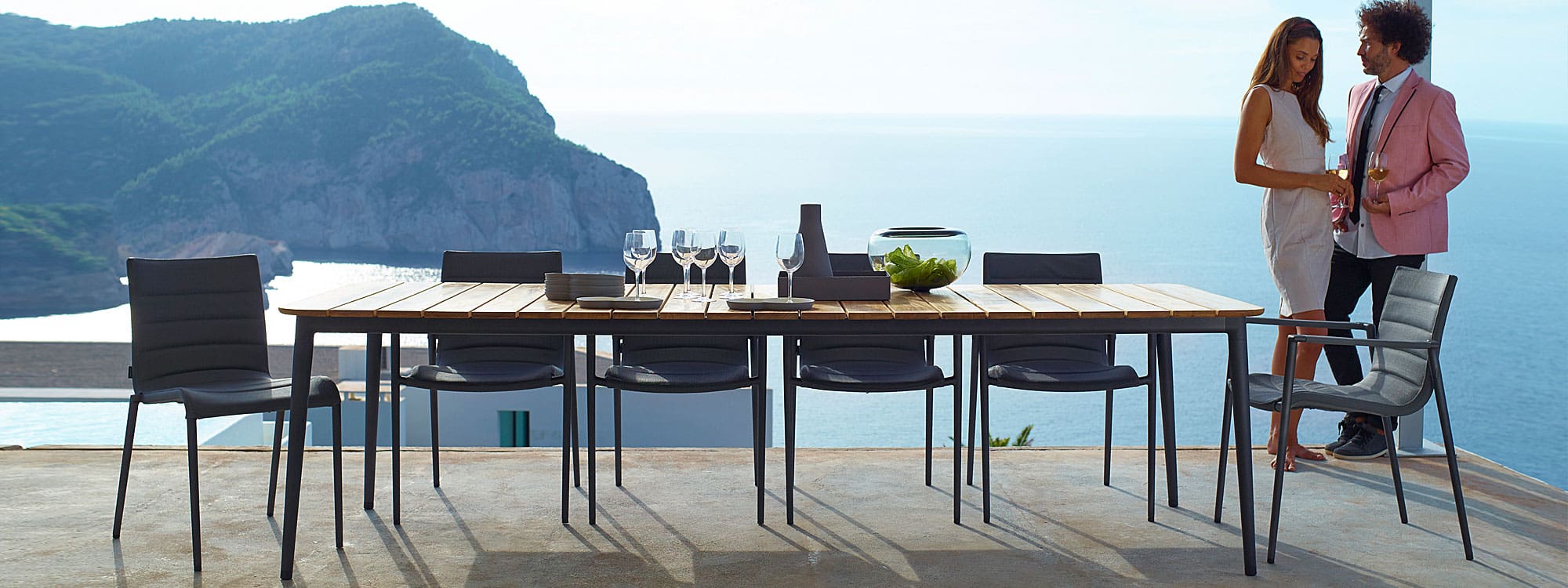 Image of couple stood next to Core garden dining set by Cane-line