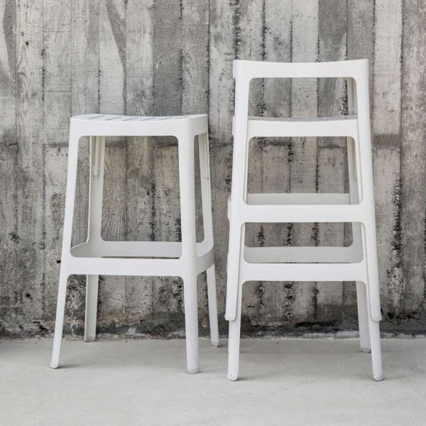 Image of stacked white Cut outdoor bar stools by Cane-line