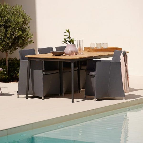 Image of poolside with Core aluminium garden table with teak top surrounded by Diamond outdoor armchairs by Cane-line