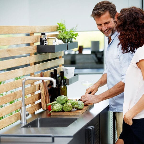 Image of man preparing artichokes on work surface of Drop outdoor kitchen by Caneline