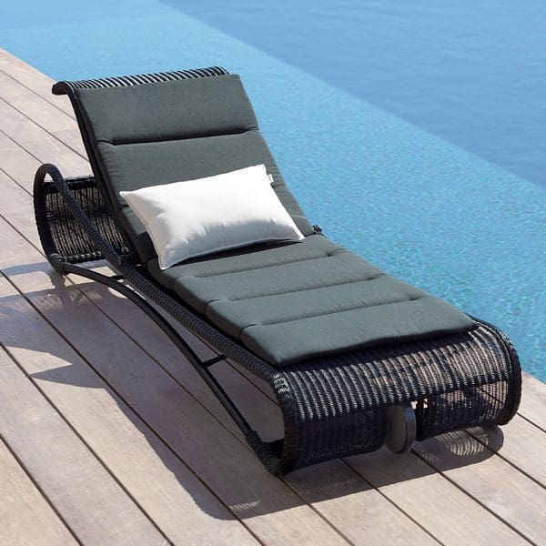 Image of Cane-line Escape black sun lounger with wheel on decking next to swimming pool