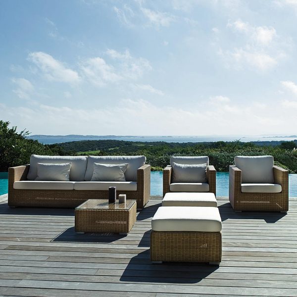 Image of Chester natural finish cane garden sofa by Cane-line, on decking with sea in background stretching into distance