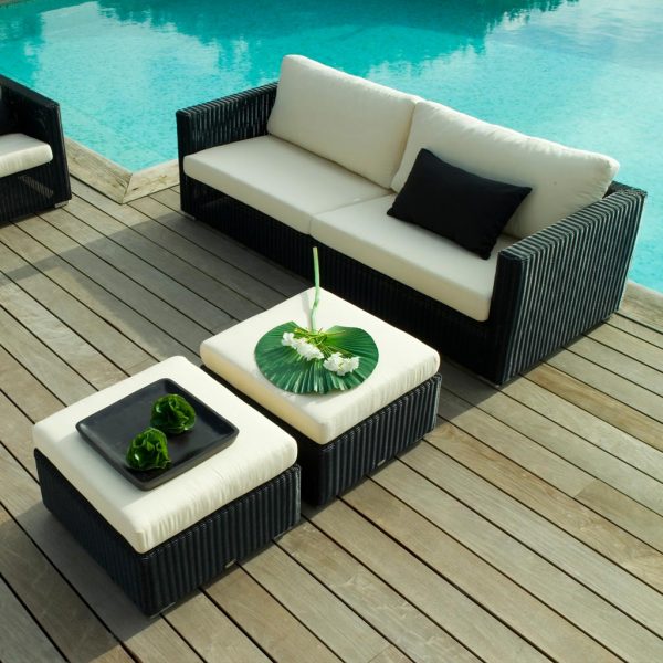 Image of Chester black rattan garden sofa and 2 foot stools with white cushions by Cane-line