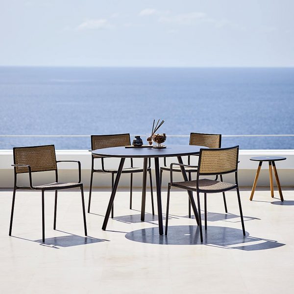 Image of Area round garden table and Less dining chairs in natural French weave and lava-grey frames by Cane-line