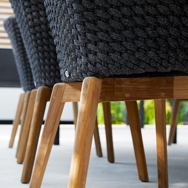 Image of detail of Peacock chair's WWF-certified teak legs and dark-grey Soft Rope seat & back by Cane-line