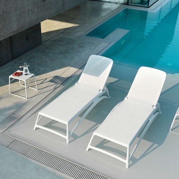 Image of aerial view of pair of Nardi Atlantico white contract sunbeds and Pop side tables, shown in sunny poolside