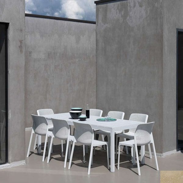 Image of Nardi Rio extending garden dining table and Net white garden armchairs, shown on sunny terrace