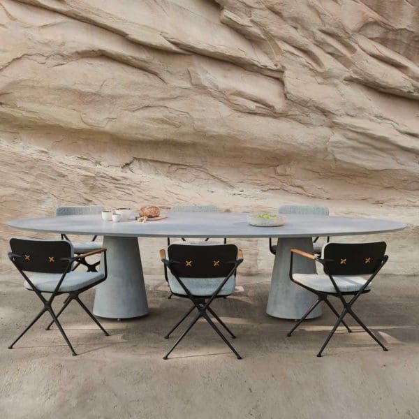 Image of Conix pedestal garden table by Royal Botania with strata of rocky cliff in background