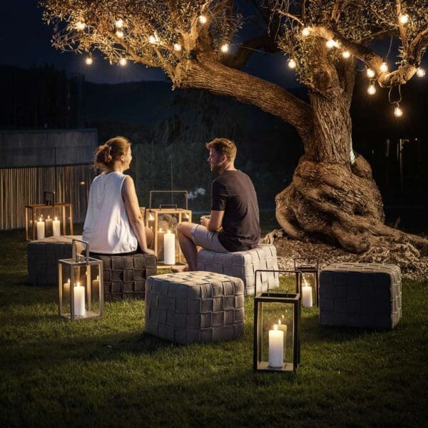 Nighttime image of Cane-line Lighthouse lanterns with candles flickering in the darkness