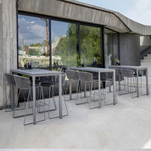 Image of outdoor bar terrace with 3 Drop bar tables and Moments grey bar stools by Cane-line furniture