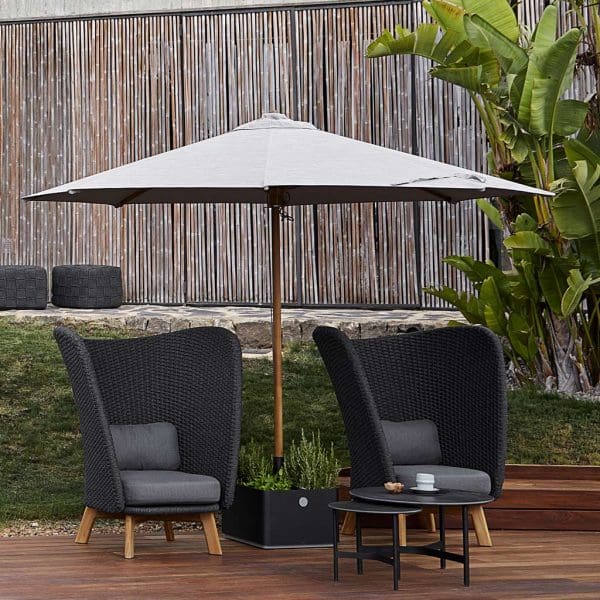 Image of 2 Caneline Peacock Wing garden relax chairs with Twist low table on poolside beneath parasol