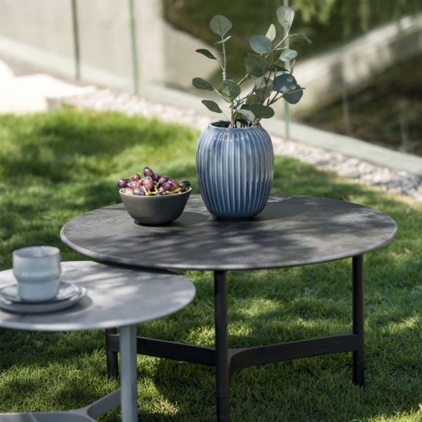 Image of pair of Twist circular low tables with ceramic tops by Caneline garden furniture