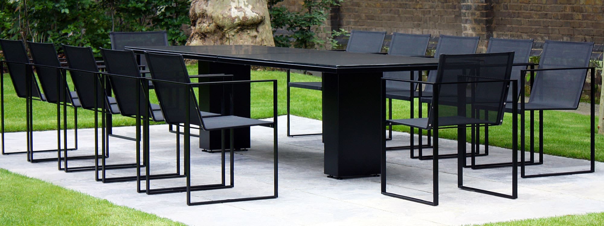 Image of large Doble black garden table and Butaque garden chairs in large London back garden