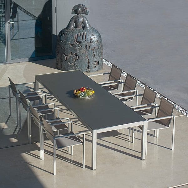 Birdseye view of sand-finish Taboela table and Alura carver chairs by Royal Botania
