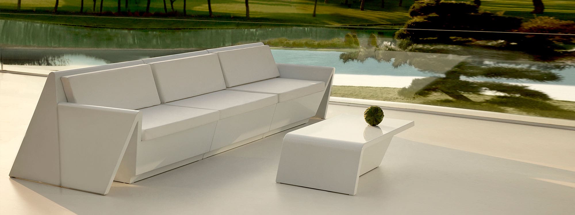 Image of Vondom Rest modern 3 seat garden sofa in white polyethylene on minimalist terrace at dusk