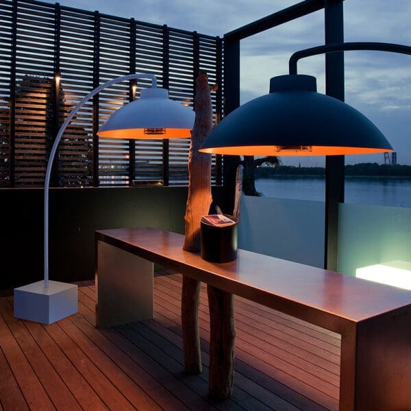 Nighttime image of pair of black and white Dome heaters over outdoor bar with louvred screen in background