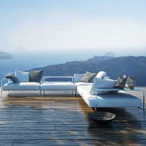 Image of Coro Sabal large outdoor corner sofa on raised terrace overlooking islands and hazy sea in the background