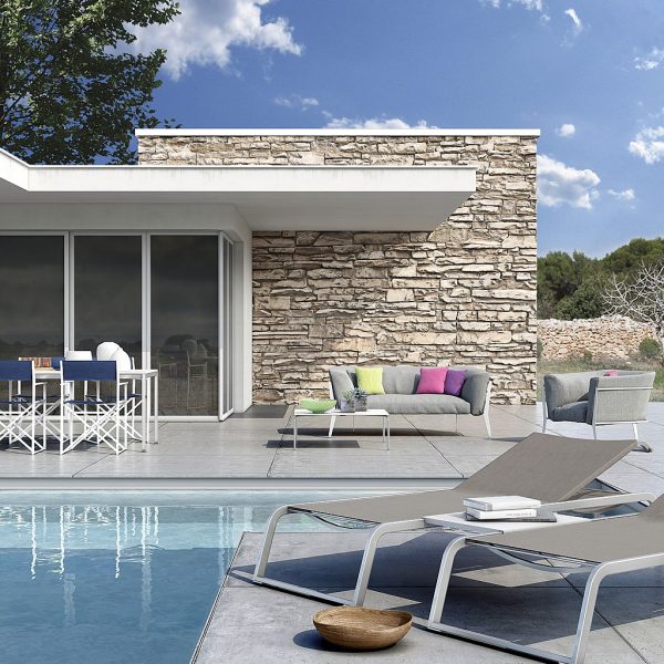 Image of Coro L3 sun loungers and Clea small garden sofa around sunny Italian poolside