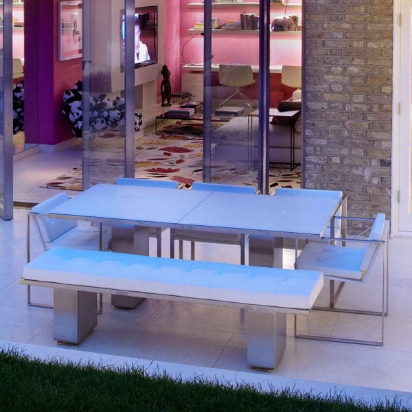 Image of Doble minimalist garden table and bench on nighttime terrace