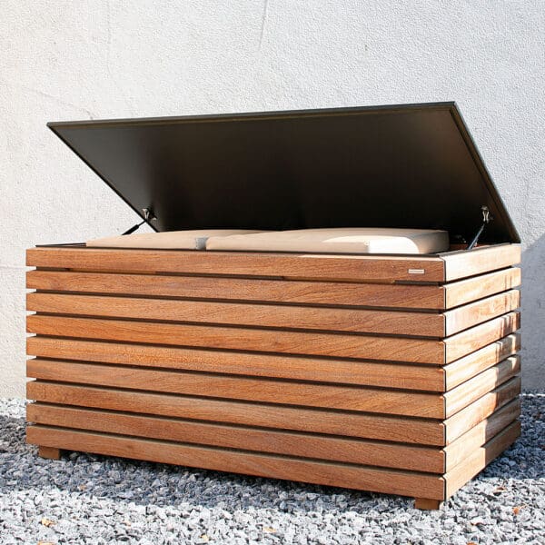 Image of Forte outdoor cushion box with its HPL lid open, shown against concrete wall