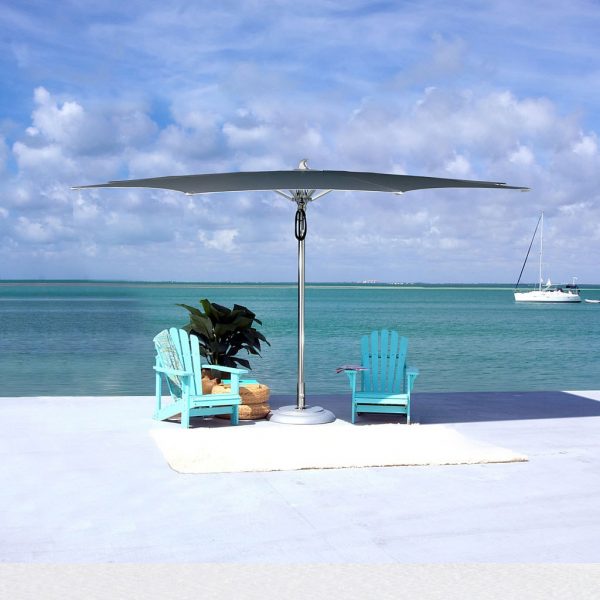 Image of Tuuci Ocean Master Max Zero Horizon mast parasol on sunny quayside, with blue adirondack chairs beneath the canopy