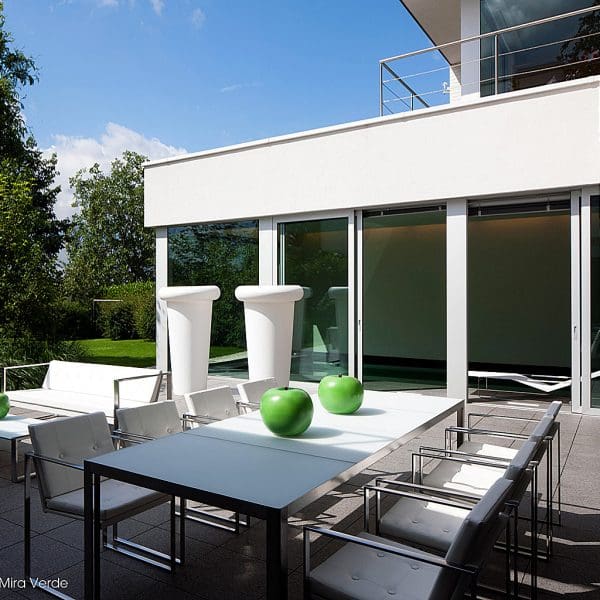 Image of FueraDentro Nimio rectangular garden table and Butaque linear garden chairs in brushed stainless steel with white Batyline seat and back