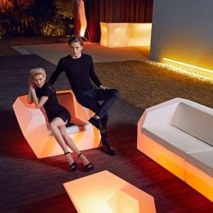 Nighttime image of couple sat on Vondom Faz illuminated garden lounge furniture
