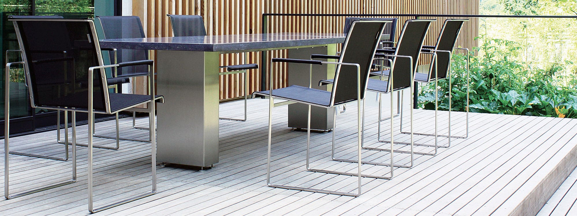 Image of Doble modern garden dining table with stainless steel base & Belgian Bluestone base with Sillon garden chairs