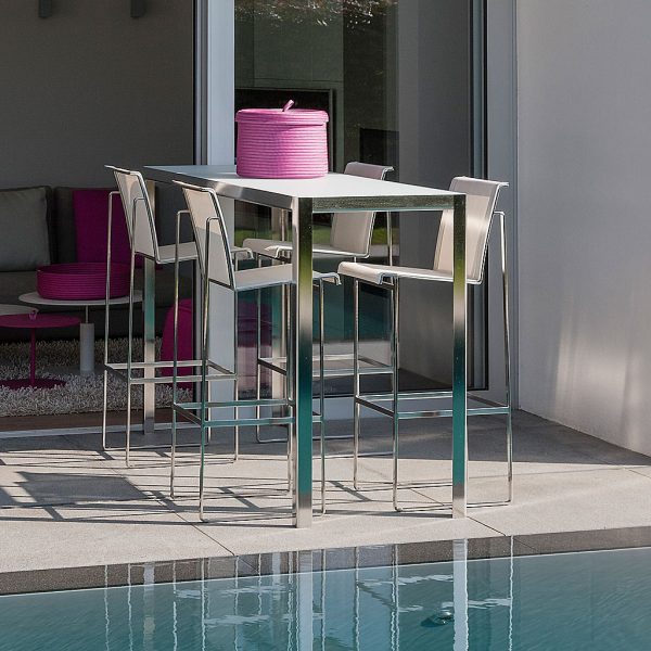 Image of 4 Taburete stainless steel bar stools and Nimio modern garden bar table on sunny poolside