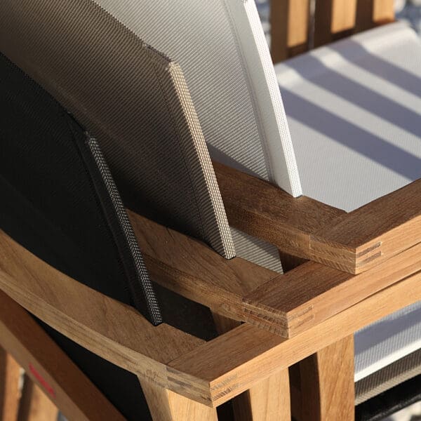 Image of detail of stacked XQI 55 teak garden chairs with backs in white, bronze and black, by Royal Botania