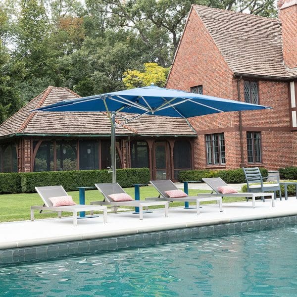 Image of Tuuci blue Ocean Master Max cantilever parasol with polished aluminum mast and ribs on poolside above sun loungers