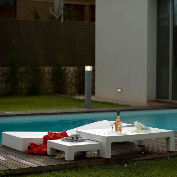 Image of Jut modern plastic sun bed and Jut white next of low tables by Vondom on sunny poolside
