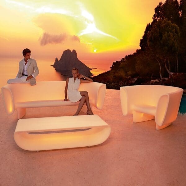 Image of Vondom Bum Bum LED illuminated garden sofa set on terrace at dusk, with plunging coastline and sea in the background