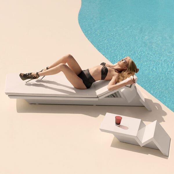 Image of woman in bikini and stylettos lying on Vondom Rest minimalist sun lounger on sunny poolside