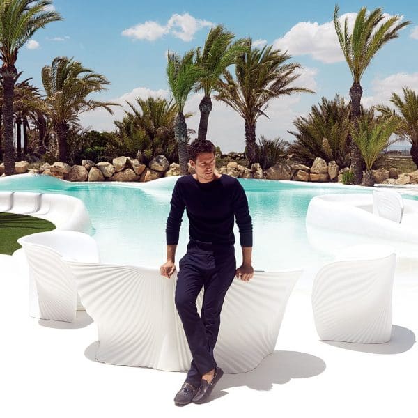 Image of man dressed in black sat on back of Biophilia modernist garden sofa by Vondom