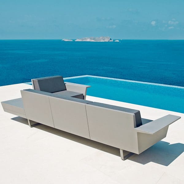 Image of rear of Vondom Delta modern garden sofa on poolside terrace, with blue sea and sky in the background