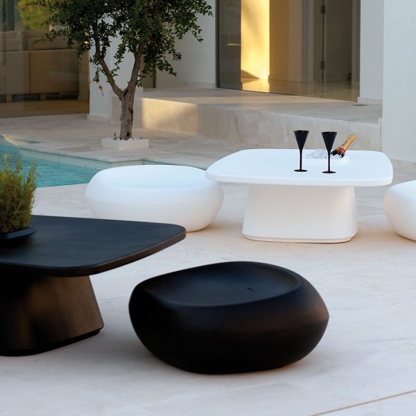 Image of black and white Moma low outdoor dining furniture by Vondom in shadows of tranquil courtyard
