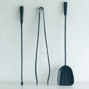 Studio image of Marco Ferreri minimalist fire irons shown leant against wall
