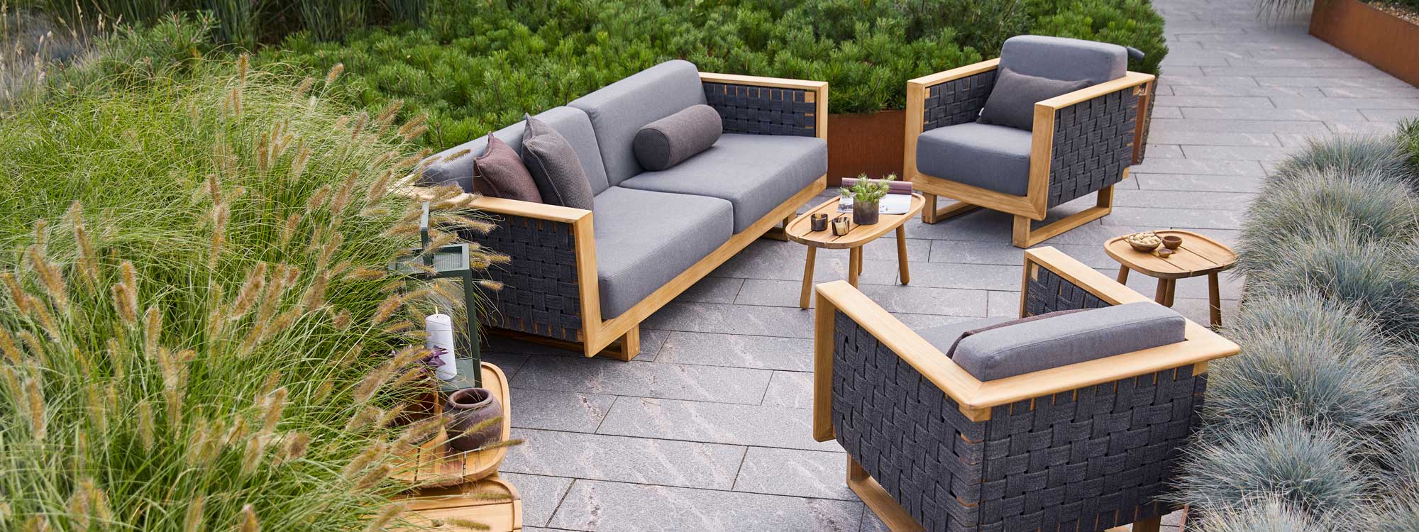 Image of Cane-line Angle outdoor lounge furniture with teak frames and grey AirTouch fabric cushions