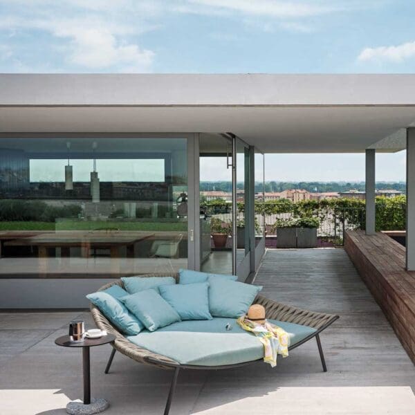 Image of RODA Arena modern garden daybed with Sand colored webbing and light blue cushions on wooden decking next to swimming pool