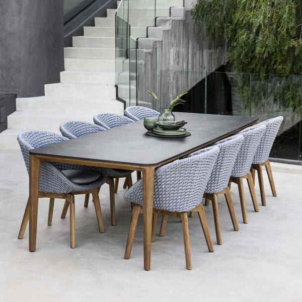 Image of Aspect teak dining table with black ceramic top and Peacock grey chairs with teak legs by Cane-line