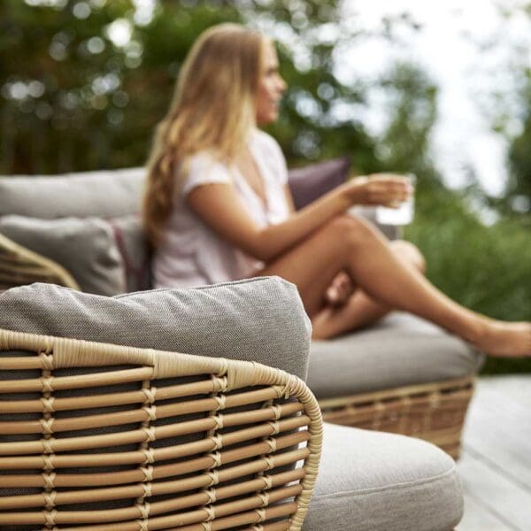 Image showing detail of side of Cane-line Basket garden furniture, shown in natural Cane-line weave with taupe cushions