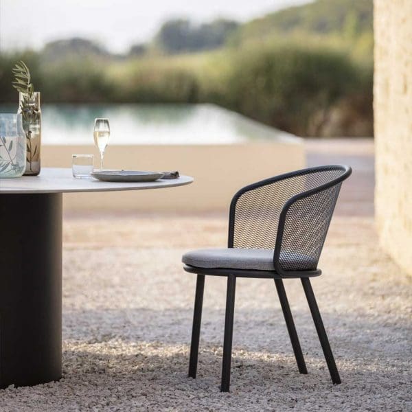 Image of Baza anthracite garden chair and Branta round garden table with swimming pool and countryside in the background
