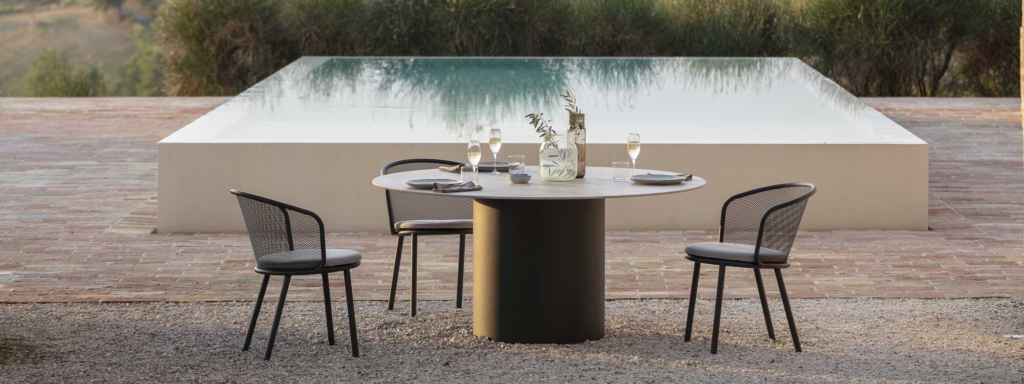 Image of Baza outdoor chair and Branta round garden table in front of swimming pool