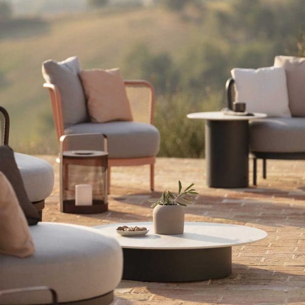 Image of Todus Baza contemporary garden lounge chairs and Branta minimalist low tables on terrace, with scorched hills in background