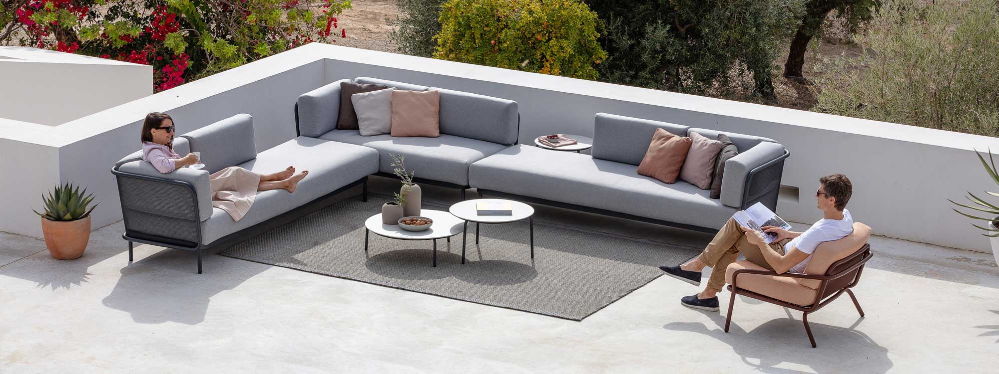 Image of aerial view of couple relaxing on large Baza garden corner sofa and Starling outdoor lounge chair & low tables by Todus