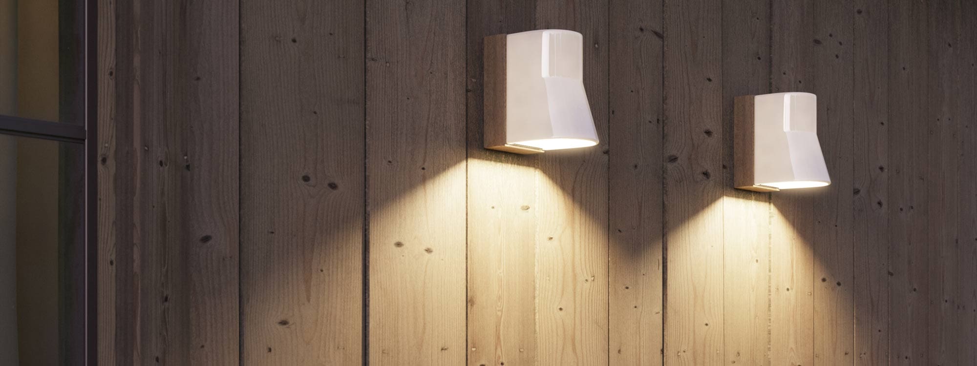 Image of pair of illuminated Beamy modern wall down lights in white porcelain by Royal Botania