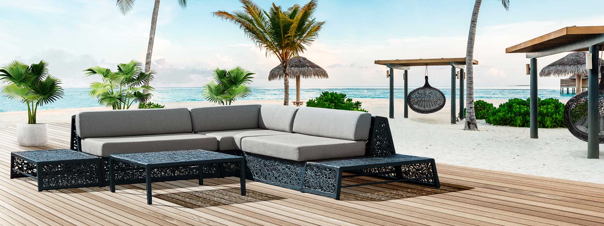 Image of Bios Lounge furniture in black with grey cushions by Unknown Nordic, with palms and Bios Hide swing seats in background